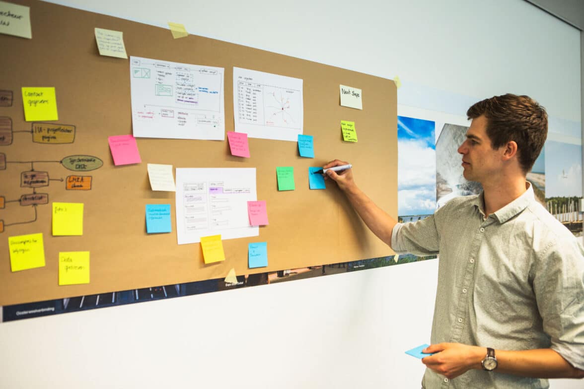 Consultant plakt post-it notitie op brown paper