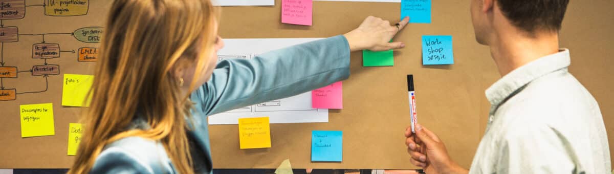 Twee consultants bekijken een post-it notitie op brown paper