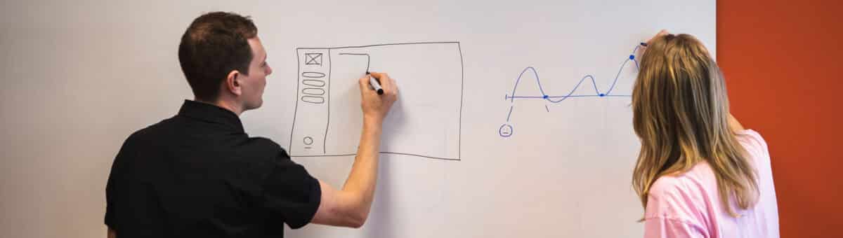 Twee GriDD consultants schrijven op een whiteboard