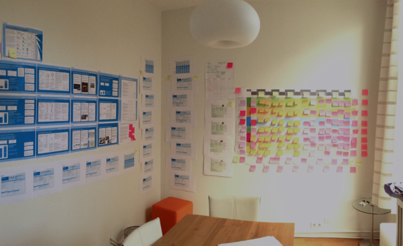 Post-its, wireframes en onderzoeken op muur voor redesign Philips Lghting